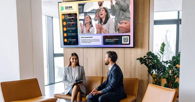 Empleados frente a pantalla de comunicación interna Vixonic