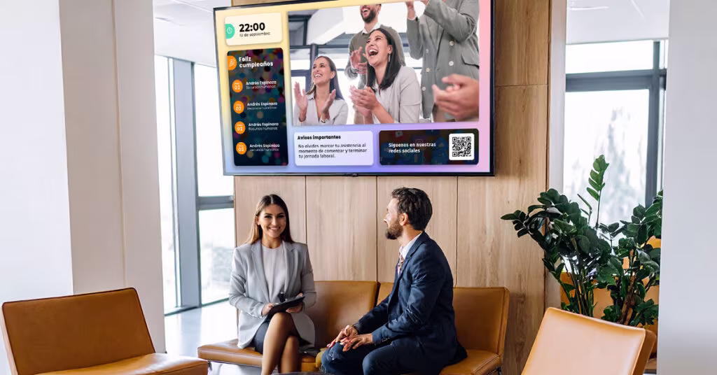 Empleados frente a pantalla de comunicación interna Vixonic